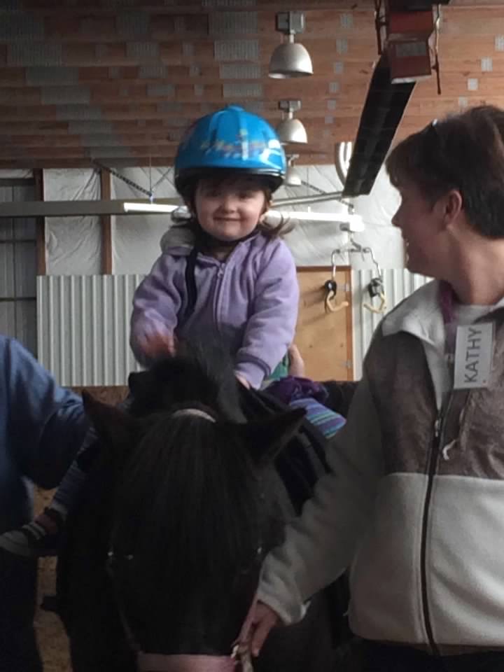 Amelia at her first hippotherapy lesson on a horse.