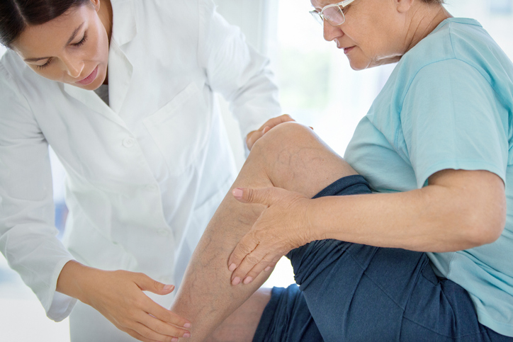 Doctor checking patients leg. 
