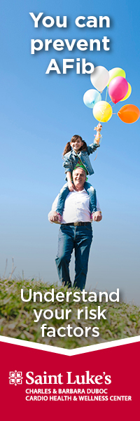 A grandfather holds his daughter, who is holding balloons