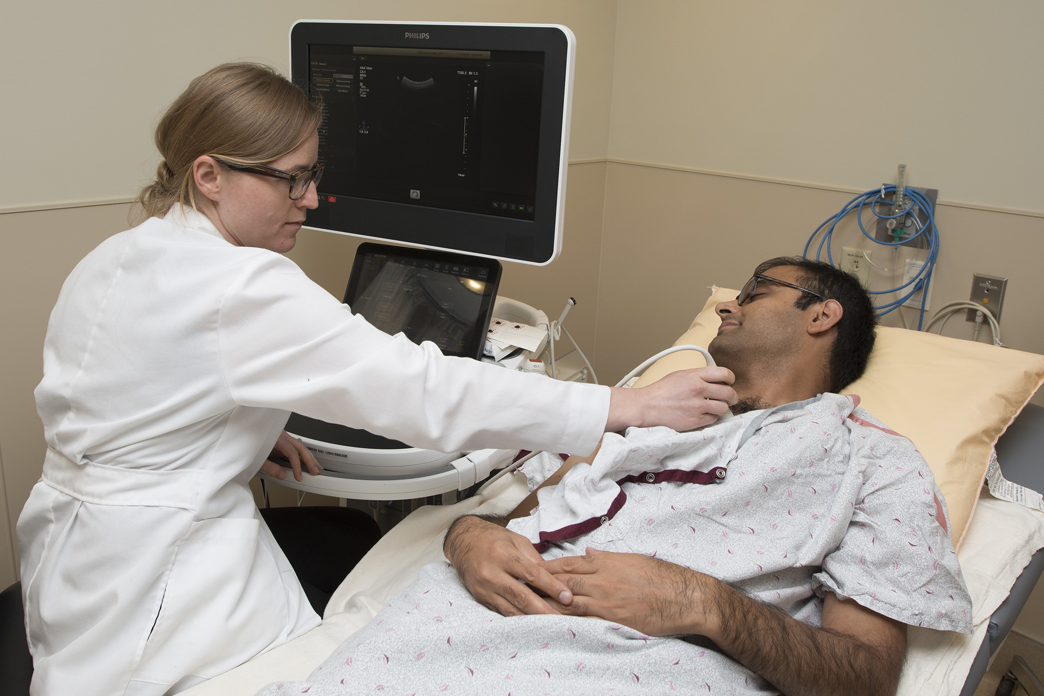 A cardiovascular fellow uses an echocardiography machine. 