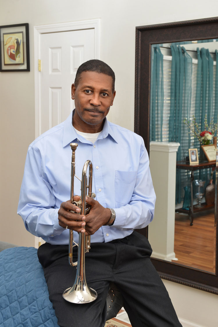 Fabian, a colon cancer patient, holds his trumpet