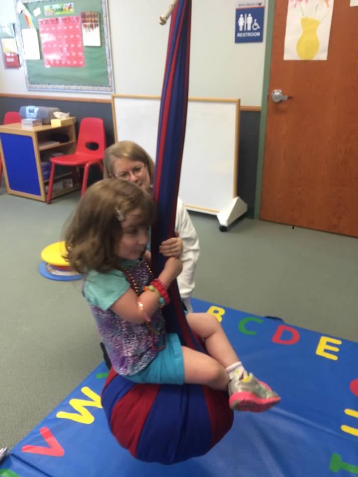 Amelia started occupational therapy with Teri Tankel at the SPOT when she was 3 years old. Teri works on fine motor skills, motor planning, proprioception, and daily living skills. Amelia loves the swings at the SPOT!  This photo is from the summer of 2016. 