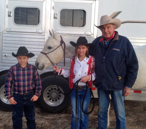 Duane with his great-grandkids, Wesley and Katy, standing by his horse. 
