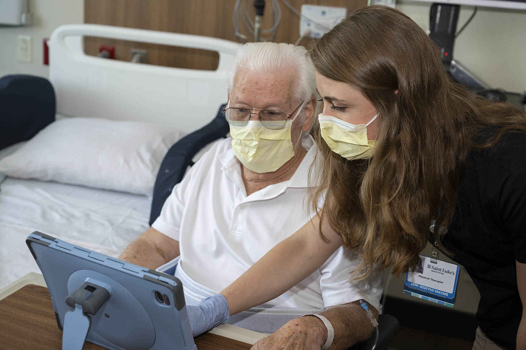 A Saint Luke's physical therapist helps connect Don and his daughter in a video chat through Saint Luke's Friends and Family Program. 