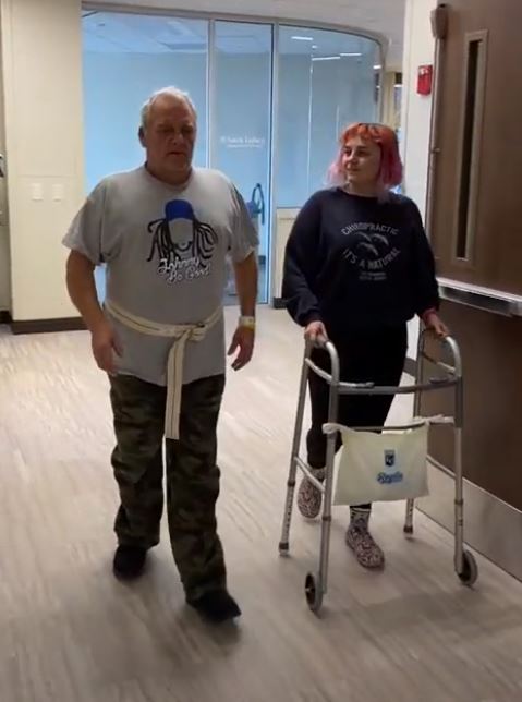 Birch walking the halls of Saint Luke's Rehabilitation Institute with his daughter Hannah