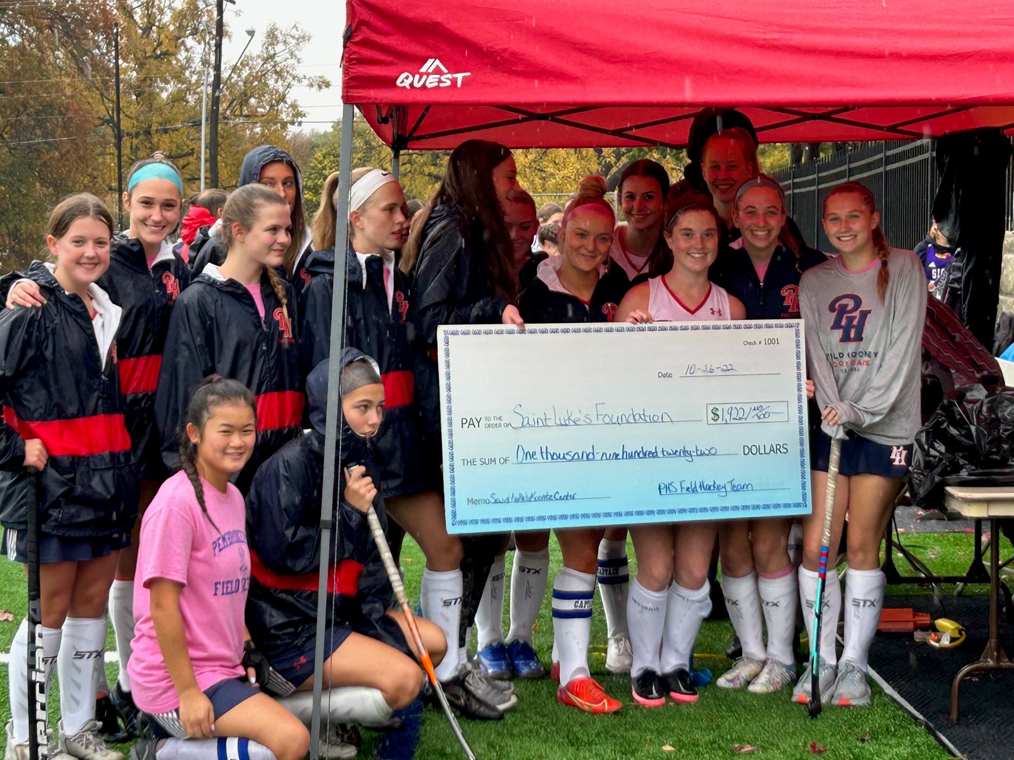 The Pembroke Hill Field Hockey Team braved the rain to present their check to Saint Luke’s Hospital Koontz Center for Advanced Breast Cancer.