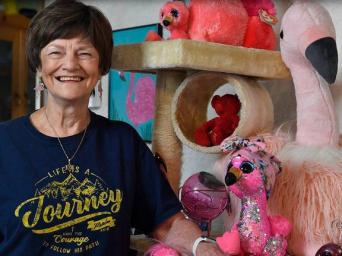 Nita Jestila smiling with her flamingo collectibles in her home
