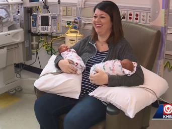 Mother holds her twins in Saint Luke's NICU while talking with KMBC9 News about being a part of 12 sets of twin sin the NICU.
