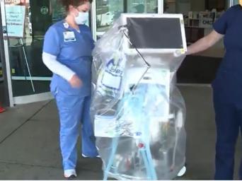 A respiratory therapist and ICU nurse manger bring out a ventilator. 