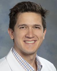 Dr. Nathan Lightfoot in a white coat. 