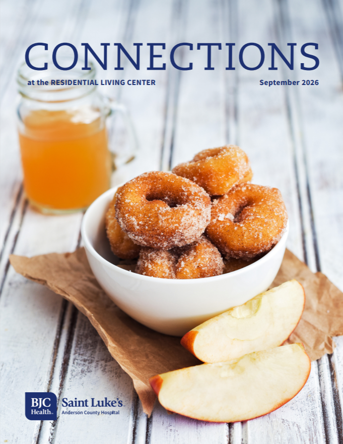 A bowl of donuts, with a couple slices of apple next to the bowl. 
