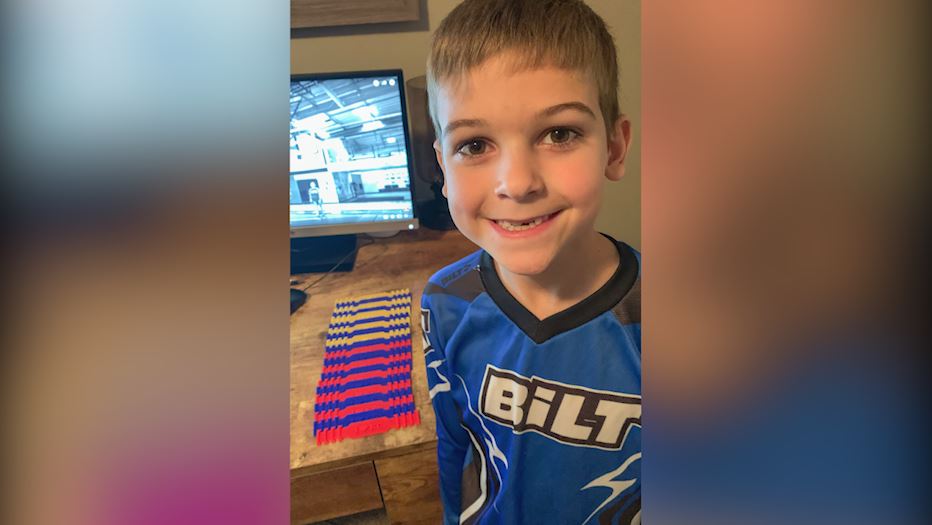 Ethan Stimac smiles with his 3D printed mask bands for Saint Luke's employees