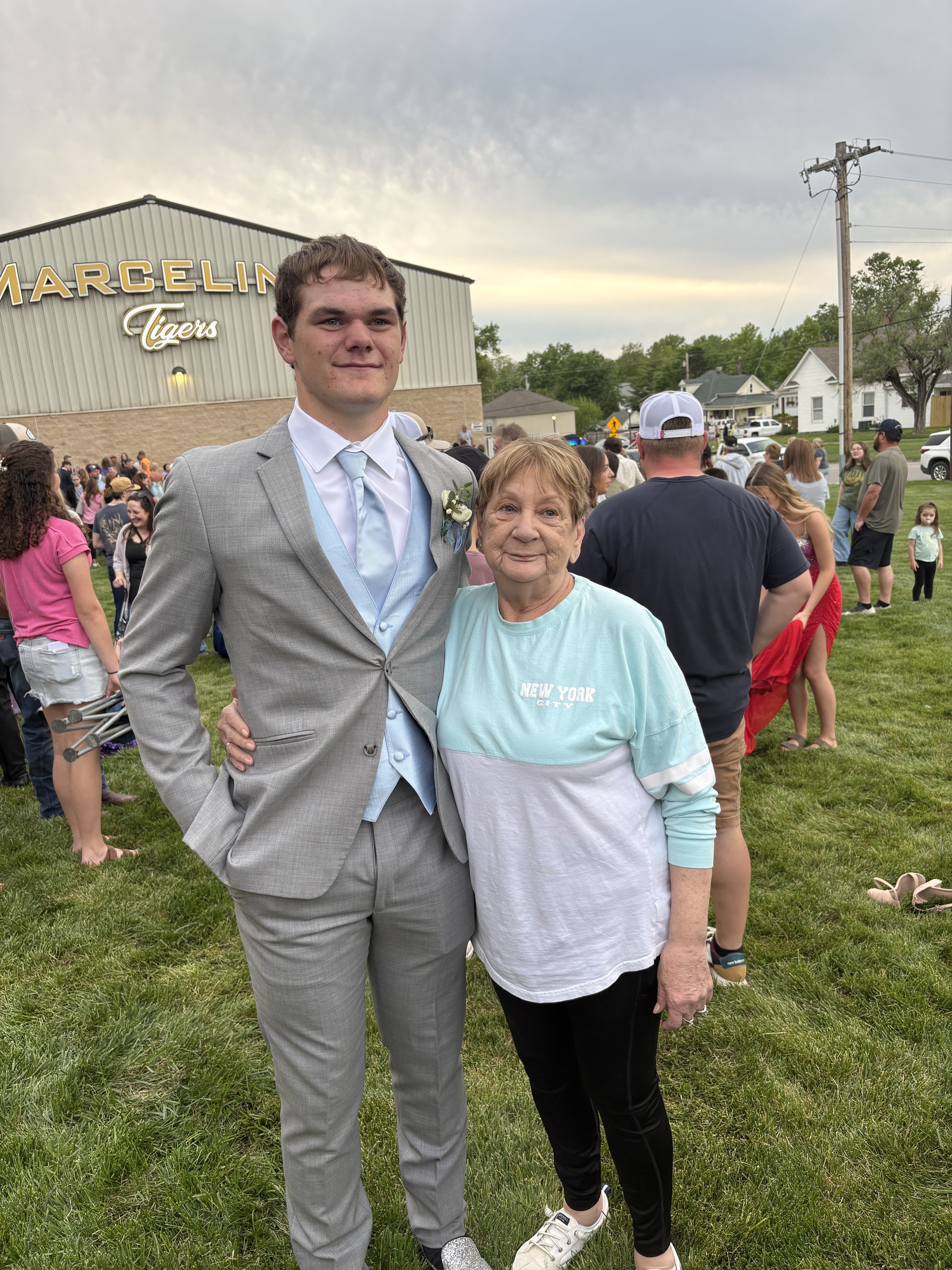 Dorothy Esser (right) and her grandson standing in front of Marceline Tigers stadium 