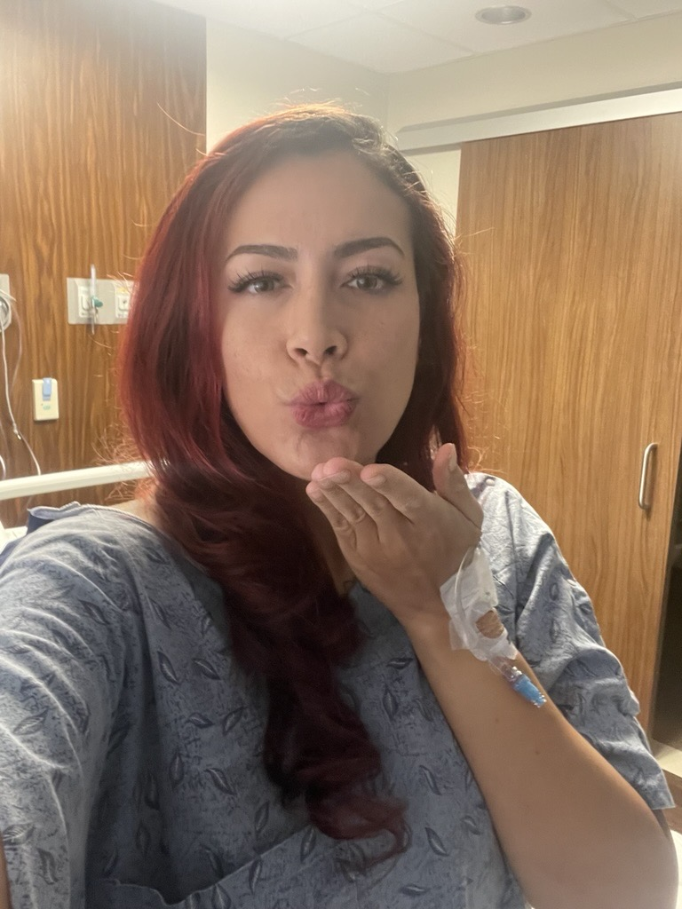 35 old patient Jo in hospital scrubs, blowing a kiss 